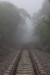 Fototapeta na wymiar Railroad tracks disappearing into the mist
