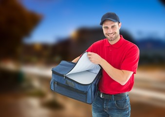 Happy pizza deliveryman with delivery bag in the city at evening