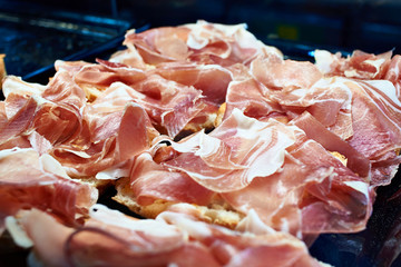 Sliced Spanish jamon on counter of store
