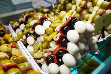 Canapes with olives and quail eggs on store