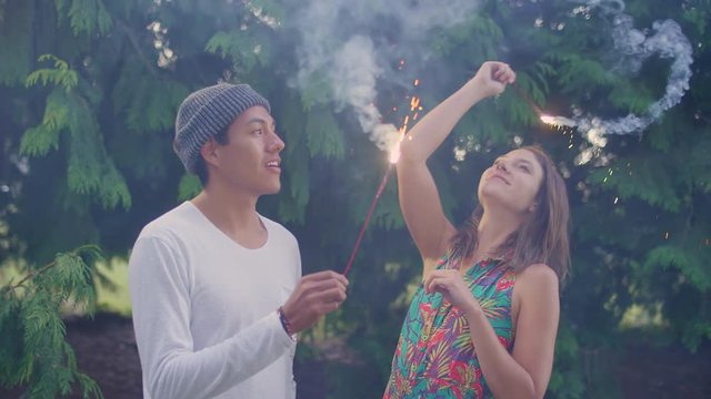 A young hipster couple playing with sparklers