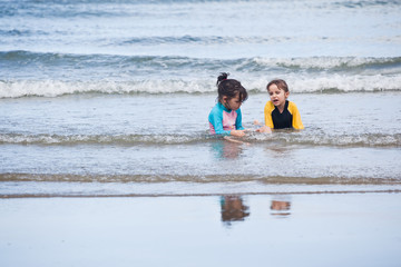 Obraz premium Little girls playing on the beach, family beach vacation