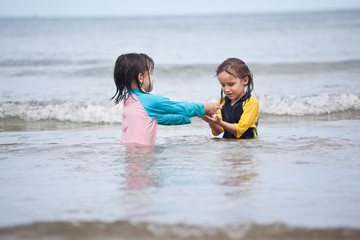 Fototapeta premium Little girls playing on the beach, family beach vacation
