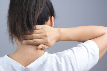 Woman putting her hand for neck or spine pain