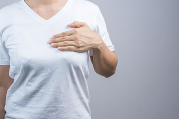 Woman putting her hand on breast for checking size or cancer awareness