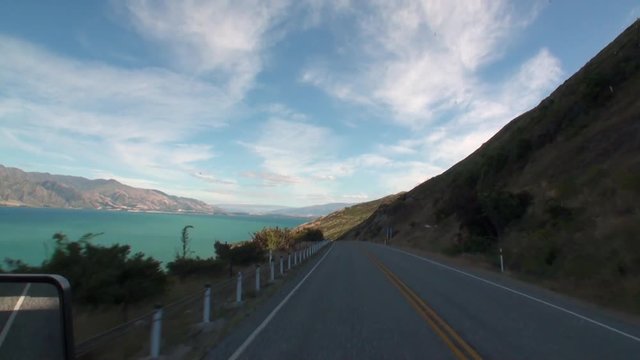 Serpentine road on ocean coast panorama view from car window in New Zealand. Scenic peaks and ridges. Beautiful background of amazing nature. Travel and tourism in the world of wildlife.