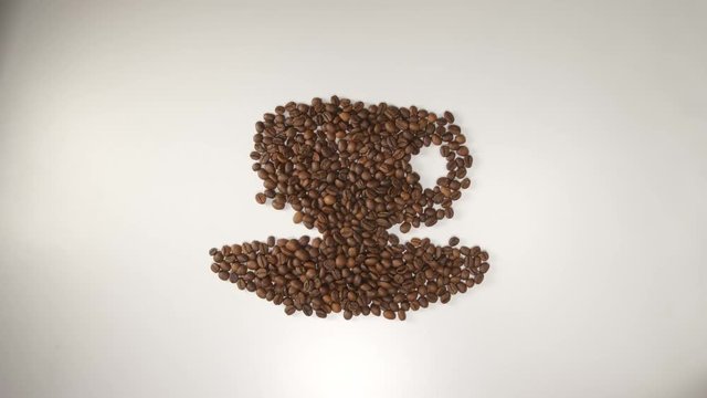 TOP VIEW: Coffee beans transform to symbols: bean, cup and heart (stop motion)