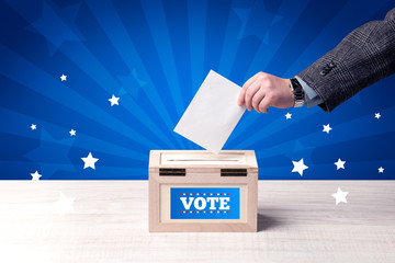 hand with ballot and wooden box