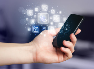 Hand holding smartphone with mobile app icons