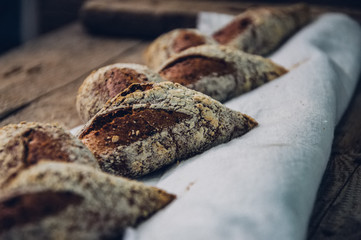 Close up fresh baguette on a sackcloth. Dark rustic style. Toned.