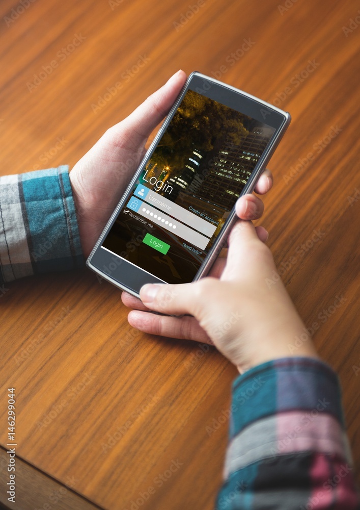 Poster hands with phone on a table, login on the screen
