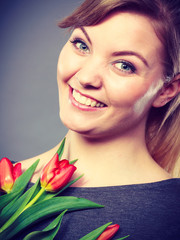 Happy blonde woman with spring flower.