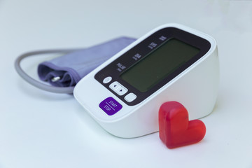 Digital blood pressure meter with love heart symbol  on white background