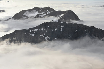Mountain tops piercing through thick layer of clouds
