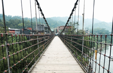 Fototapeta na wymiar Hanging bridge over river