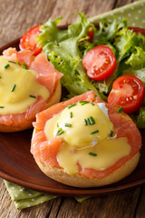 Delicious breakfast: eggs Benedict with salmon and hollandaise sauce close-up. vertical