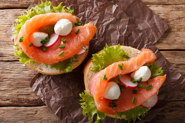 sandwiches with smoked salmon, mozzarella, lettuce and radish close-up. Horizontal top view