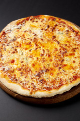 Hot pizza Quattro Formaggi on a rustic wooden table.