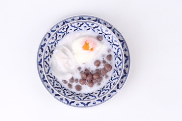 Purple potato dumplings with poached egg and coconut roll in sweet coconut cream .