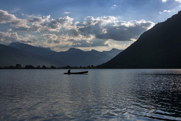 A rowing silhouette in evening mountain lake