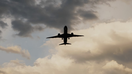 Fototapeta premium Passenger airplane taking off at sunset against the background of a very beautiful clouds.
