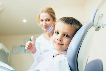 Little cute boy at the dentist looking at the camera and smiling.