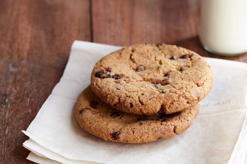 Chocolate chips cookies on the wooden table with milk in background. quick and eays meal in the morning.