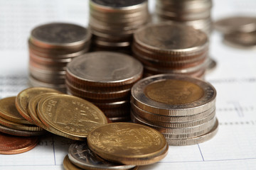 Coins stack with blue home toys on passbook. Saving, income and payment concept.