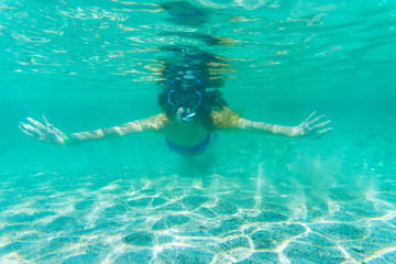 Underwater shoot of a young lady snorkeling and doing skin diving in a tropical sea