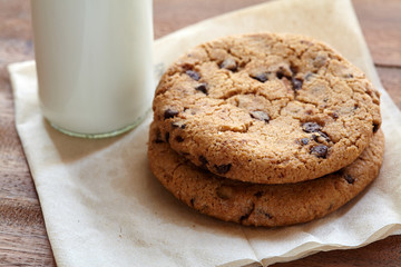 Chocolate chips cookies with milk bottle in background on the wooden table. quick and easy meal in the morning. Close up shot.