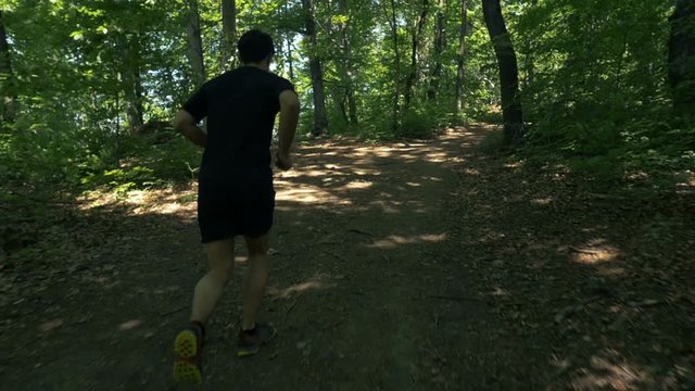 a young man running in the green woods