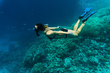 Young girl at snorkeling in the tropical water. Traveling, active lifestyle concept.