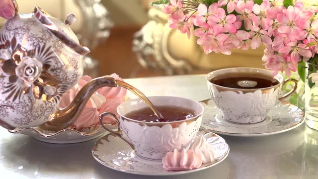 Tea Pouring. Porcelain cup of Healthy Tea closeup. Slow motion video footage 240fps 