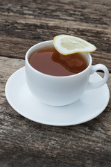 cup of tea with lemon on wooden background