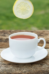 cup of tea with lemon on wooden background