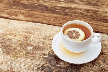cup of tea with lemon on wooden background