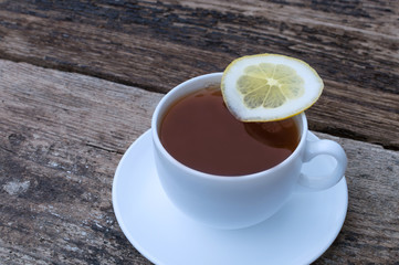 cup of tea with lemon on wooden background