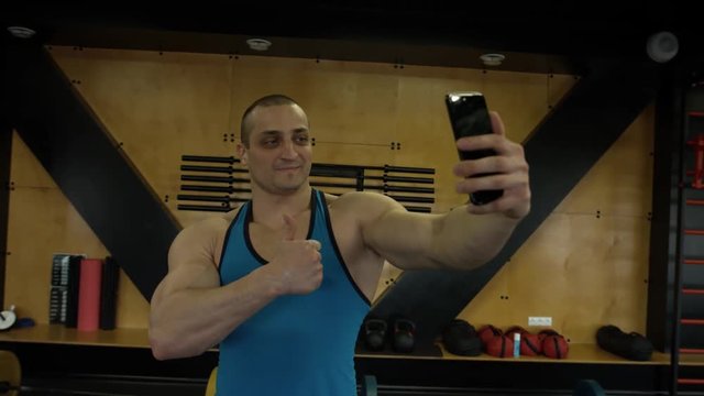 The athlete makes a selfie photo in the hall of crossfit