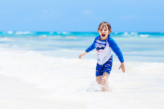 little blond kid boy having fun on tropical beach of Maldives