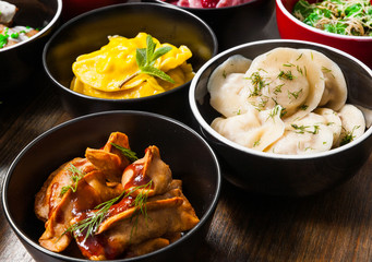 Set of different dumplings and ravioli on a wooden table