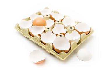 Cartón de huevos morenos rotos con fondo blanco