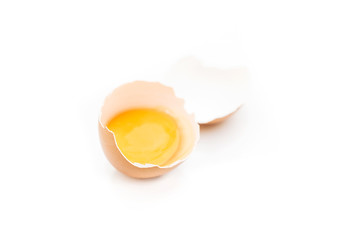 Huevo moreno roto con fondo blanco y yema dentro