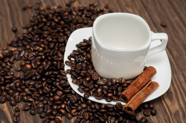 Empty white coffee cup with coffee beans on the table