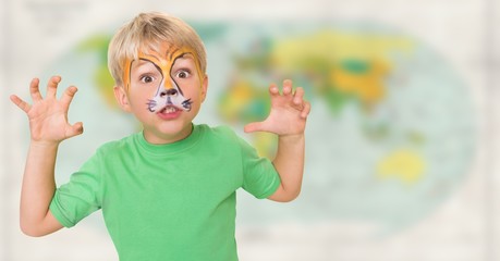 Boy with facepaint growling against blurry map