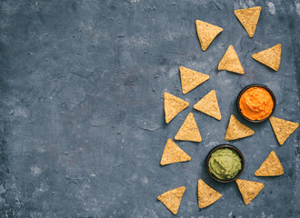 Mexican food concept: tortilla chips, guacamole and salsa over vintage background. Top view. Flat lay. Copy space