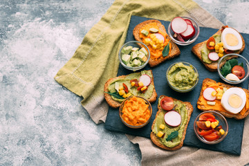 Traditional latinamerican mexican sauce guacamole with ingredients on dark background. Top view