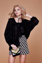 Fototapeta premium Portrait beautiful young sexy girl with long blonde hair with natural makeup wearing shorts and jacket silk top accessory bad fashion model clothing style catalog spring collection cosmetic for face.