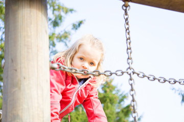 Blondes Mädchen auf Klettergerüst