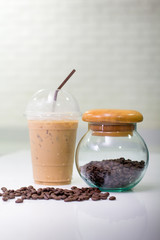 coffee beans with Coffee jar and Ice coffee on modern kitchen table.(focus jar)