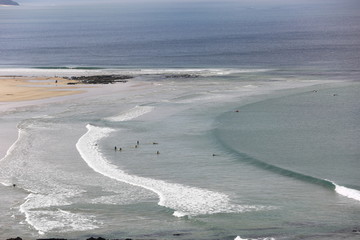 Fototapeta na wymiar Surfers test the tides at a beach along the Great Ocean Road in Melbourne Australia